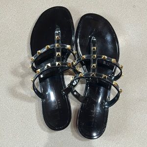 Black and gold studded flip flops